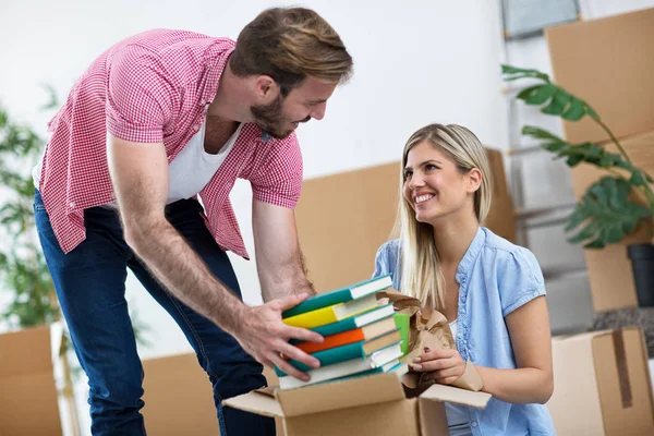 Junges Paar packt Bücher in die Kartons — Stockfoto
