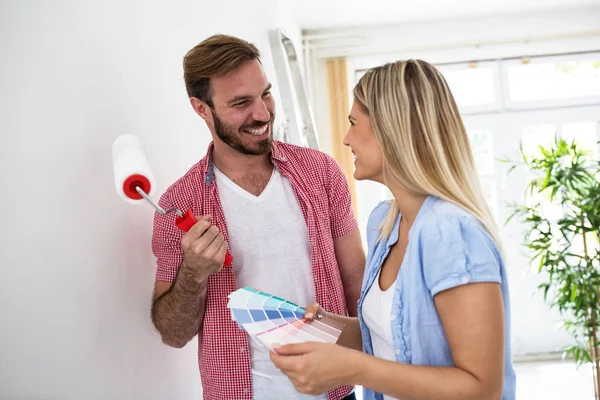 Joven feliz pareja elegir colores — Foto de Stock