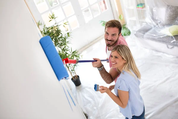 Atractiva pareja joven pintando paredes — Foto de Stock