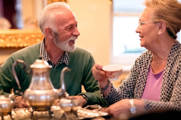 Pasangan senior yang cantik tersenyum dan minum teh di panti jompo — Stok Foto