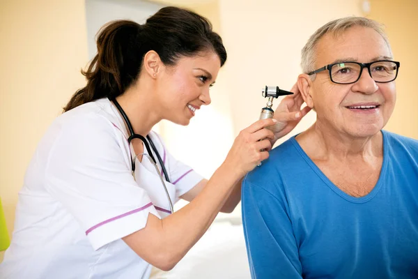 Orelha de exame médico com otoscópio na clínica do lar de idosos — Fotografia de Stock