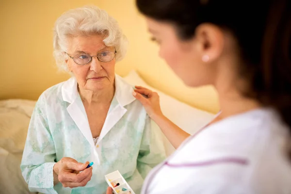 Sad alone senior woman taking a drog from daily box — Stock Photo, Image