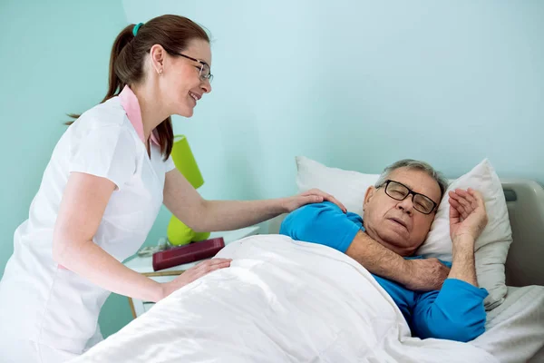 Nice tersenyum perawat melihat pasien yang tidur dan bermimpi — Stok Foto