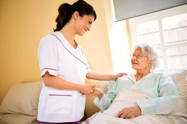 Wanita senior pasien dengan perawat di panti jompo — Stok Foto
