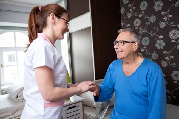 Careful nurse holding hand of senior patient and comfort him — Stock Photo, Image