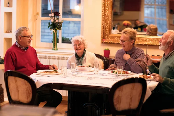 Orang tua menikmati dan tersenyum saat makan malam — Stok Foto