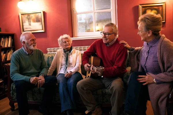 Personas mayores haciendo fiesta sonriendo y disfrutando juntos en casa — Foto de Stock