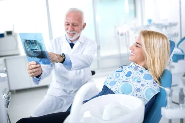 Le dentiste et le patient envisagent des traitements nécessaires de la teet — Photo