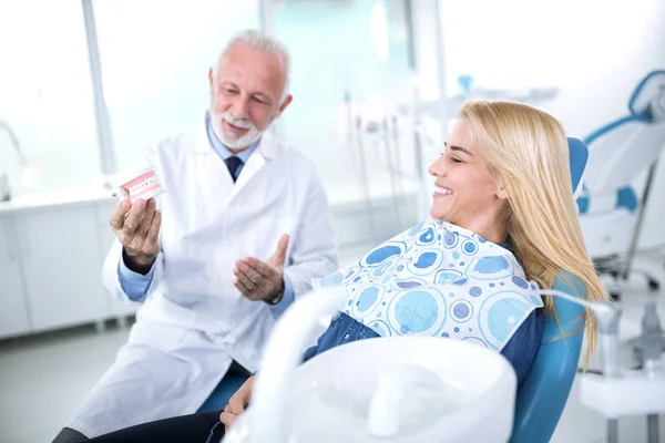 Стоматолог показывает пациенту результаты протезирования — стоковое фото