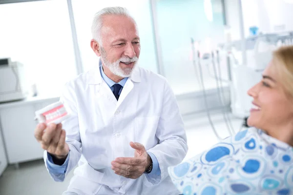 Zahnarzt zeigt dem Patienten die Ergebnisse der Prothetik — Stockfoto