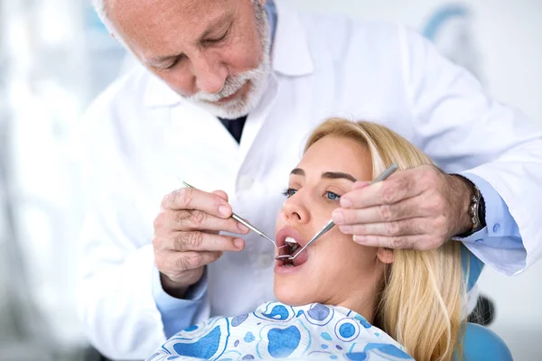 Le dentiste principal examine les dents des patients — Photo