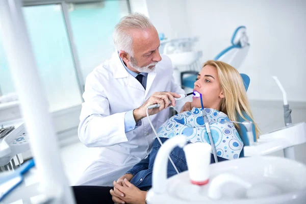 Молодая женщина посещает дантиста для проверки сломанного зуба — стоковое фото