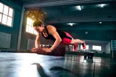 Push up uçan güçlü güçlü kadının spor salonunda, zor yoğun crossfit egzersiz yapması