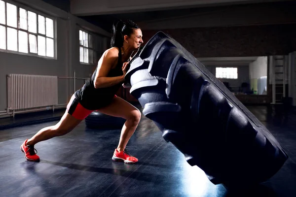 Vista Lateral Una Mujer Fuerte Empujando Neumático Durante Entrenamiento Volteando —  Fotos de Stock