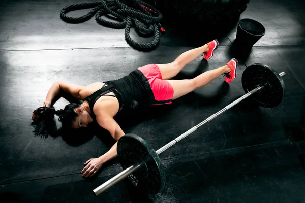 Crossfit zor eğitim ağırlıkları yalan sonra yorgun genç kadın