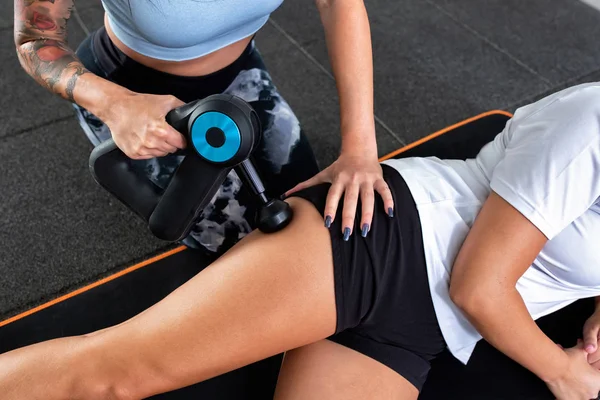 Masaj tabancasıyla üst kalça masajı.