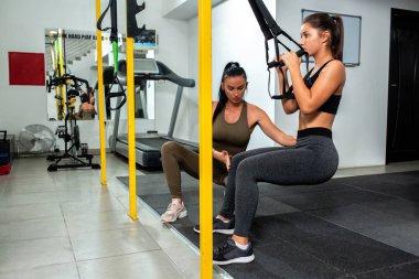 Kişisel bayan antrenör egzersizin doğru formunu gösteriyor.