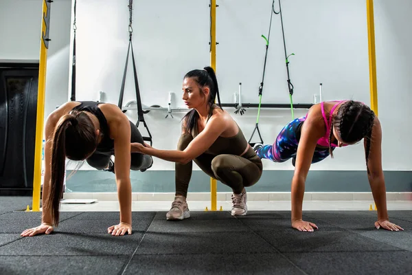 Chicas haciendo flexiones con los pies elevados —  Fotos de Stock