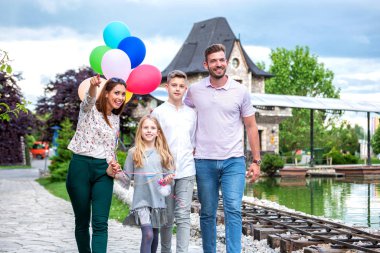 Mutlu ebeveynler çocuklarıyla yürüyüşe çıkıyor. 