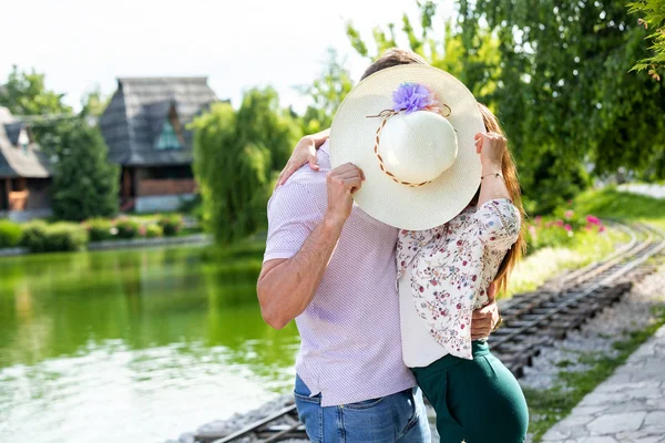 Berciuman di belakang topi musim panas — Stok Foto
