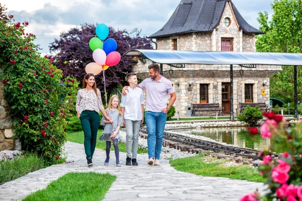 Familjemedlemmar i en familjevandring med ballonger — Stockfoto