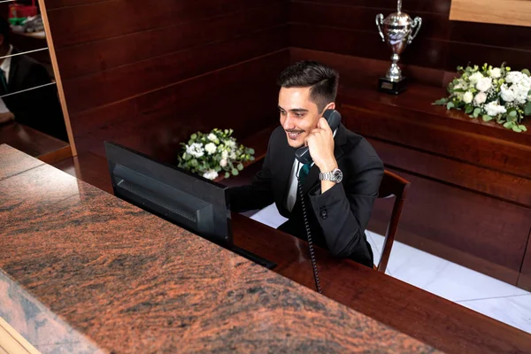 Trabajadora recepcionista hablando por teléfono — Foto de Stock