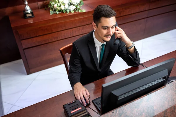 Receptionist in abito nero seduta e di lavoro — Foto Stock