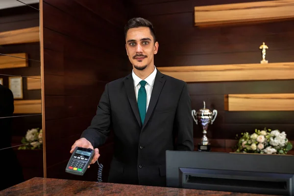 Receptionist met een creditcardlezer — Stockfoto