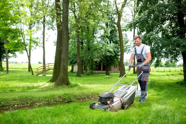 Jardinier poussant la tondeuse — Photo