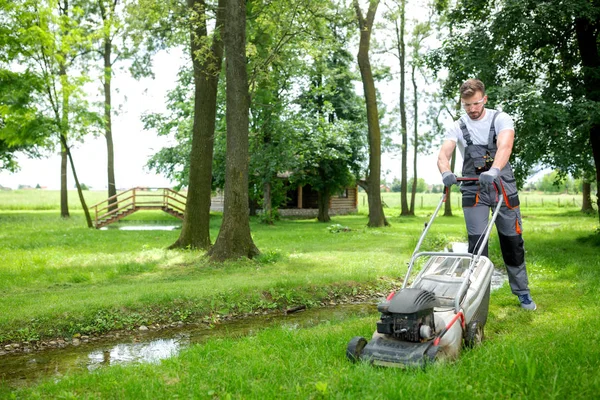 Lawn mowing next to a stream