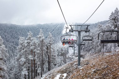 People in the cableway heading for a ski track
