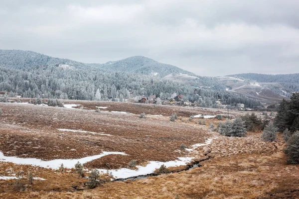 Glace de montagne enneigée avec maisons au loin — Photo