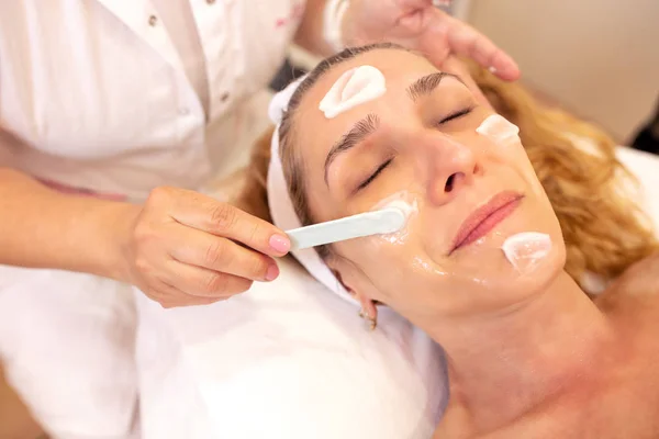 Cosmetician putting face cream on her client���s skin — Φωτογραφία Αρχείου