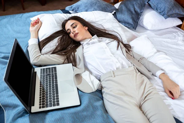 Fatigué jeune femme d'affaires reposant sur le lit — Photo