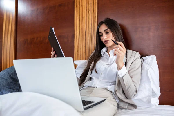Wanita bisnis yang elegan duduk di tempat tidur — Stok Foto