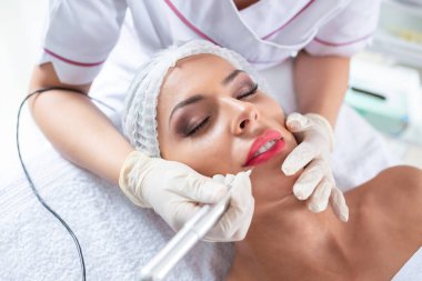 Güzel bir kadının dudaklarında kalıcı makyaj tedavisi uygulanır.