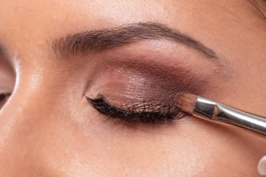 Göz kapağına makyaj yapıyor ve kaş rengine uyuyor.