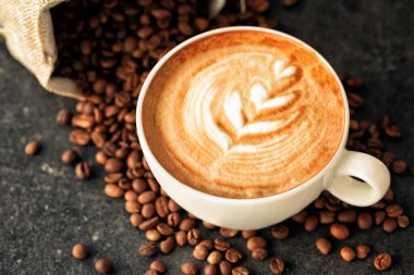 Kahve çekirdeği dökülmüş bir fincan espresso, kahve konsepti.