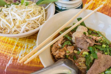 şehriye çorbası yemek çubukları ile