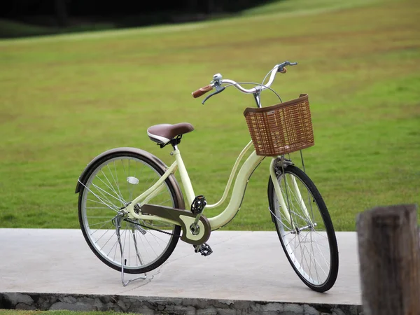 กรยานส เหล องม ตะกร าพลาสต าตาลจอดอย บนพ นคอนกร — ภาพถ่ายสต็อก