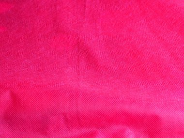 Kumaşta kırışıklıklar, kırmızı soyut tekstil, pamuk desenli arka plan.