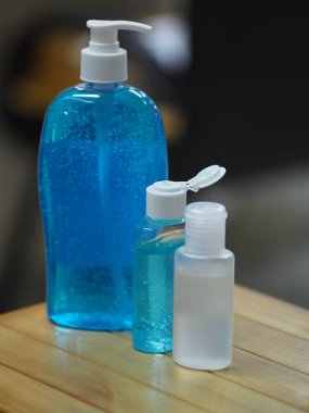 Ahşap masadaki plastik şişede el yıkama jeli. Mikropların Colona virüsünü korumasını önlemek için temiz.