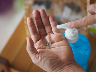 Ayakta duran ve pompa şişesine baskı yapan kadın, El Dezenfektanı, plastik şişede jelatinle karıştırılmış jel alkolü, Colona virüsünü korumak için kirli çamaşır, covid 19.