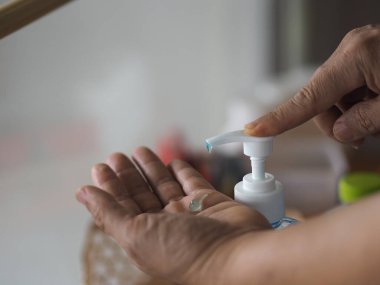 Ayakta duran ve pompa şişesine baskı yapan kadın, El Dezenfektanı, plastik şişede jelatinle karıştırılmış jel alkolü, Colona virüsünü korumak için kirli çamaşır, covid 19.