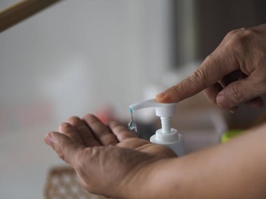 Ayakta duran ve pompa şişesine baskı yapan kadın, El Dezenfektanı, plastik şişede jelatinle karıştırılmış jel alkolü, Colona virüsünü korumak için kirli çamaşır, covid 19.