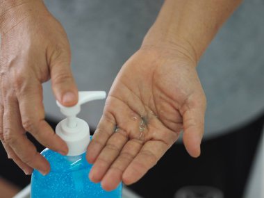 Ayakta duran ve pompa şişesine baskı yapan kadın, El Dezenfektanı, plastik şişede jelatinle karıştırılmış jel alkolü, Colona virüsünü korumak için kirli çamaşır, covid 19.