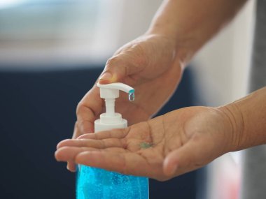 Ayakta duran ve pompa şişesine baskı yapan kadın, El Dezenfektanı, plastik şişede jelatinle karıştırılmış jel alkolü, Colona virüsünü korumak için kirli çamaşır, covid 19.