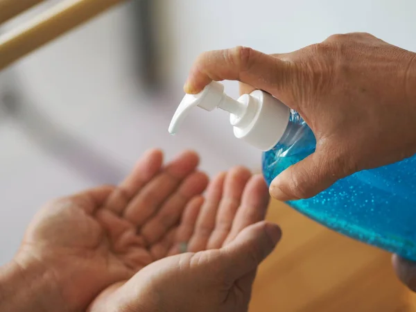 女人的手按压着瓶子的酒精凝胶泵给另一只手 用来清洁污物以防止细菌保护结肠炎病毒 Covid — 图库照片