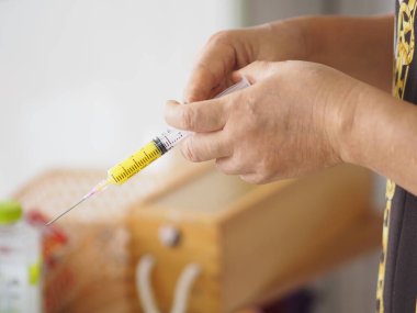 Kadın eli şırıngayı keskin bir iğneyle tutuyor.