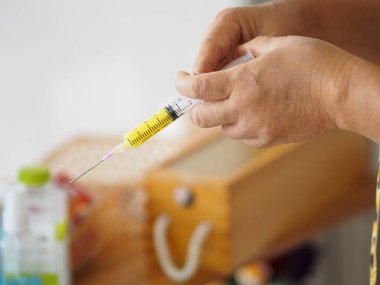 Kadın eli şırıngayı keskin bir iğneyle tutuyor.